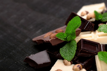 Chocolate pieces with mint leaves on black background