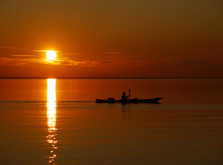 Fototapeta premium Paddler im Sonnenuntergang auf dem See
