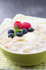 Oatmeal porridge in bowl with berries raspberries and blackberri
