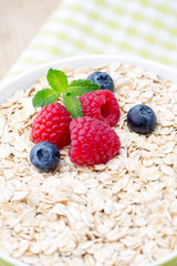 Oatmeal porridge with berries. Raspberries and blueberries.