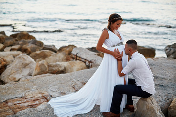 cute couple, pregnant woman stands by the sea