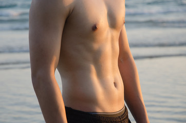 Torso of strong man against sunset