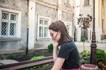 Fototapeta premium Girl in sunglasses talking on a phone, smart phone in the city, outdoors.
