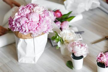Bouquet of peonies in kraft paper bag
