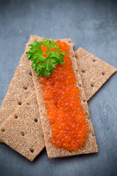Crispbread with soft cheese with herbs and salmon roe.