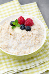 Oatmeal porridge in bowl with berries raspberries and blackberri