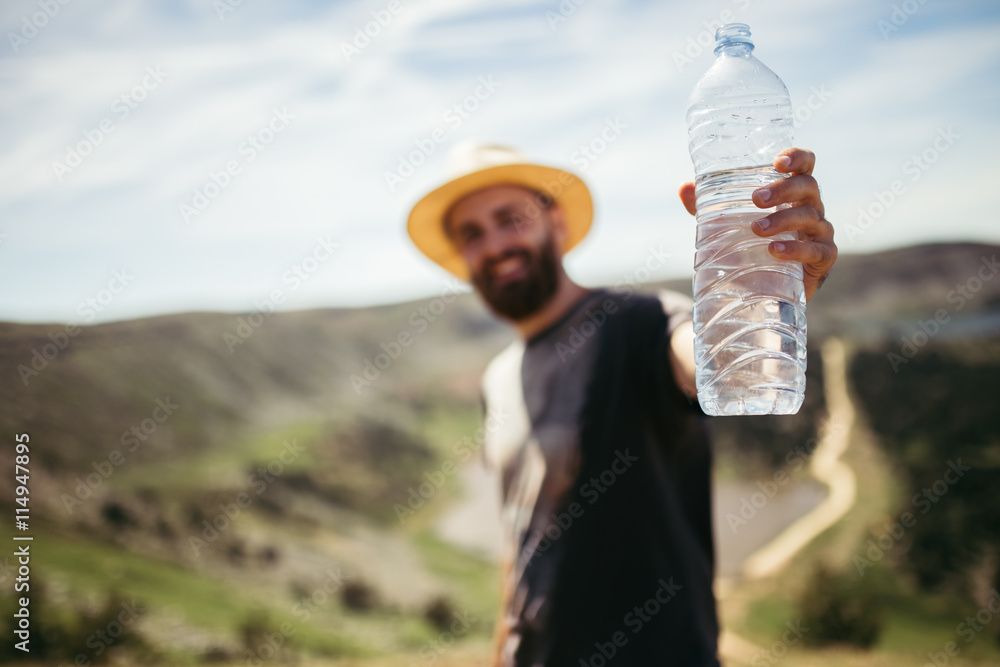 Wall mural man shows a bottle of water