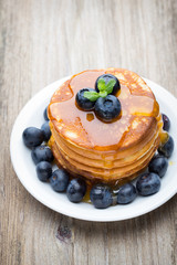 Stack of pancakes with blueberry and fresh berry.
