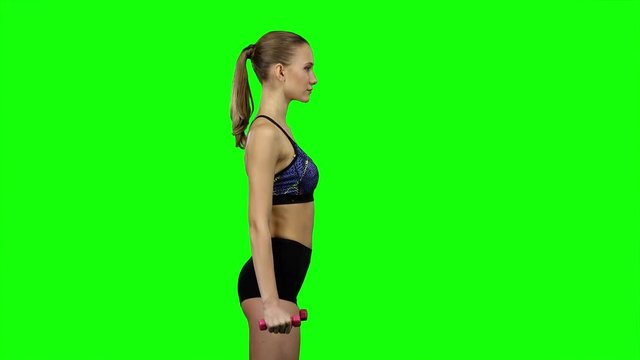 Girl with dumbbells in profile. Green screen