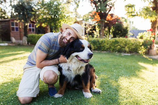 Man Hugging A Big Black Dog