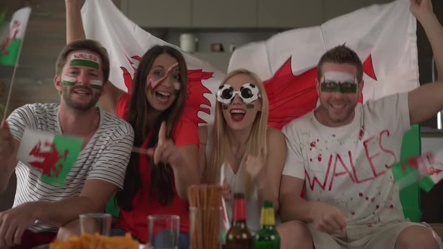 four soccer fans cheering for Wales