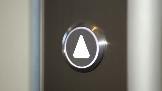 Pressing up arrow at elevator. Close up