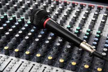 microphone on a professional sound mixing console with adjusting knobs