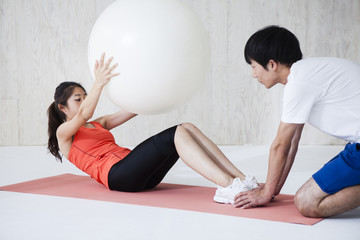 Women have a sit-ups with a balance ball