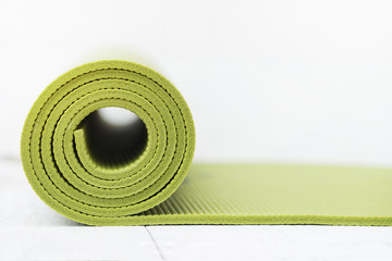 green yoga mat on white table