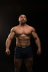 Fototapeta na wymiar handsome muscular bodybuilder posing on a black background