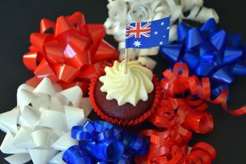 Happy Australia Day, party food with red, white and blue cupcake and Australian flag. Anzac Day. Celebration, patriotism and holidays concept - close up of glazed muffin decorated with australian flag