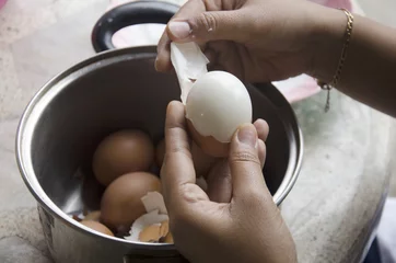 Abwaschbare Fototapete Thai woman peeling boiled egg for cooking © tuayai