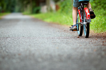 child on a bicycle at asphalt road in summer. Bike in the park