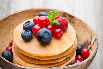 Stack of pancakes with blueberry and fresh berry.