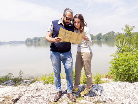 young couple of lovers consults a map outdoor