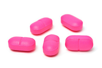 Group of pink medical pills isolated on white background