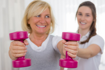 seniorin beim rehasport mit hanteln