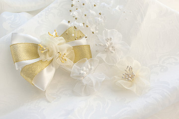 White bows with flowers on a fabric background. Wedding white ba
