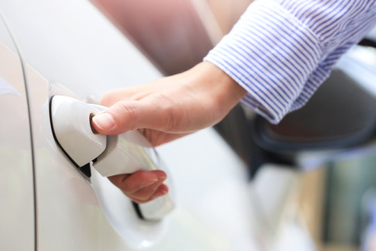Business hand on handle. Close-up female opening a car door.