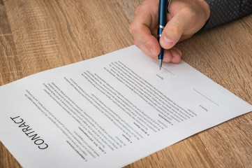 Businessman is signing a contract to conclude a deal