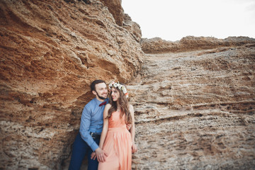 Naklejka premium Romantic loving couple walking on the beach with rocks and stones