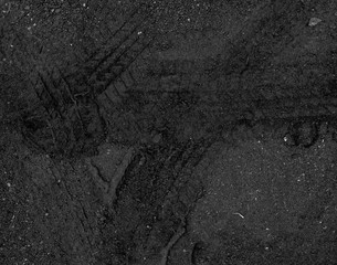 Tire tracks on the black road gravel stone background