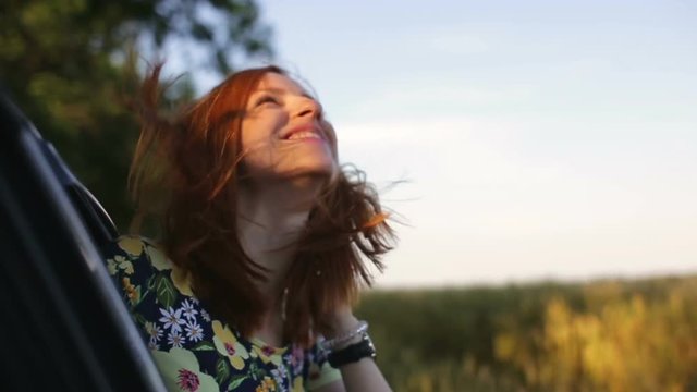 Girl leaning out of car window
