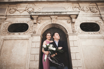 Gorgeous wedding couple, groom and bride with pink dress walking in the old city of Krakow