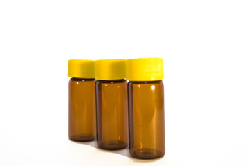 three brown glass bottles with yellow plastic caps on white background