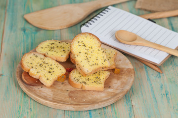 garlic bread and paper note on wood table