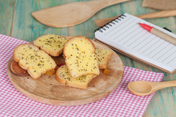 garlic bread and paper note on wood table