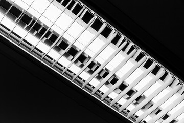 White neon lamp glowing over black ceiling