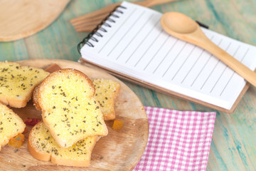 garlic bread and paper note on wood table