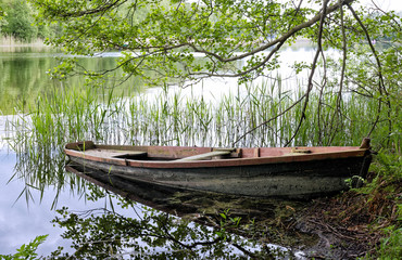 Abandoned wooden fishing boat at lake shore