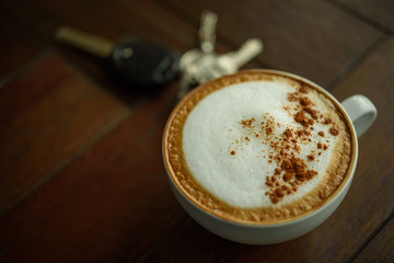 Latte coffee and keychain on wood table