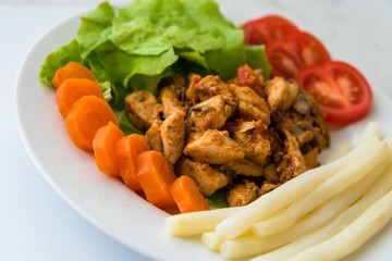 Fried chicken meat served on plate with white asparagus, carrot, tomato and lettuce. Selective focus.