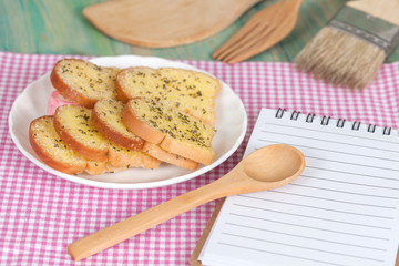 garlic bread and paper note on wood table