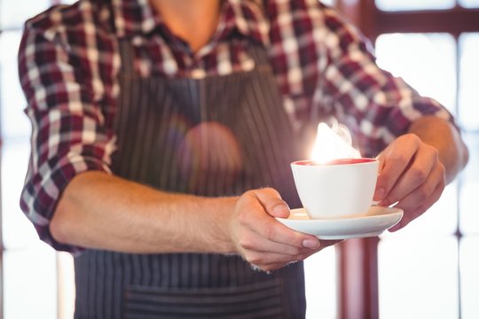 Mid Section Of Waiter Serving A Cup Of Coffee