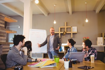 graphic designer discussing chart on white board 