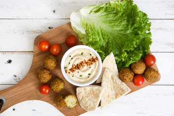 Falafel ball with hummus on cutting board