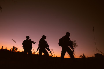 Fototapeta na wymiar Silhouette of military soldiers with weapons at night. military concept.