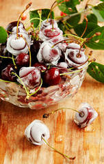 ripe cherries,ice cubes on wooden table, selective focus