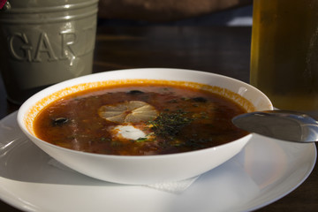 Soup Solyanka bar on the coast, a glass of beer and Cutlery in the background