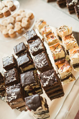 Delicious and tasty dessert table with cupcakes shots at reception closeup